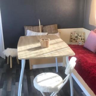 a table and chairs in a room with a bed at Coachella in Lanouaille