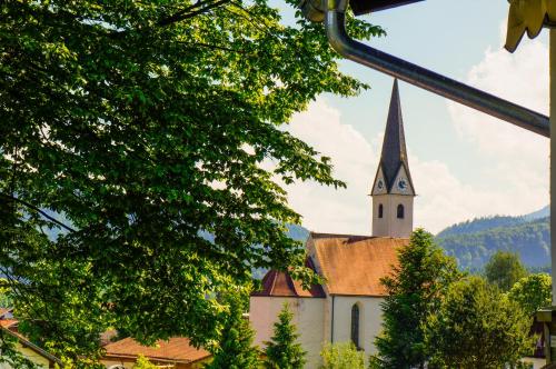 a church with a steeple in the distance at Landgasthof Zur Post in Schwangau