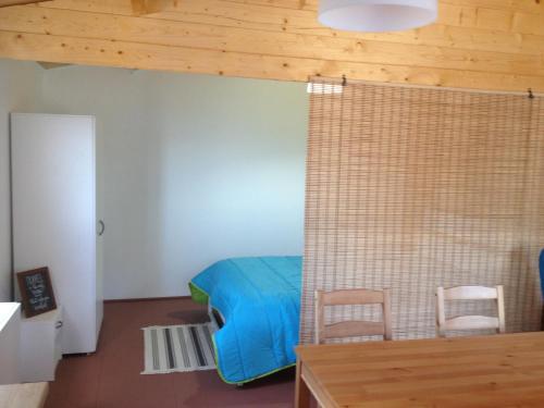 um quarto com uma cama azul e 2 cadeiras em São Jorge Spot - Alojamento em Velas
