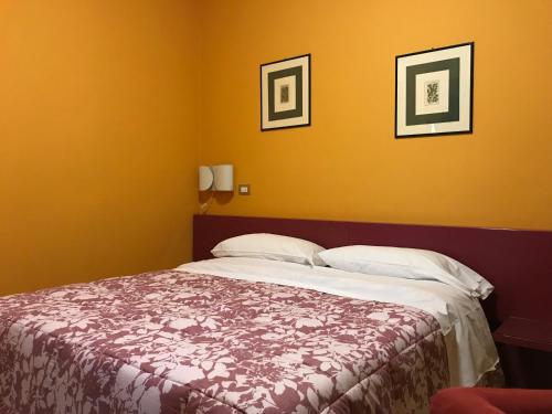 - une chambre avec un lit et deux photos sur le mur dans l'établissement Cristal Hotel, à Manocalzati