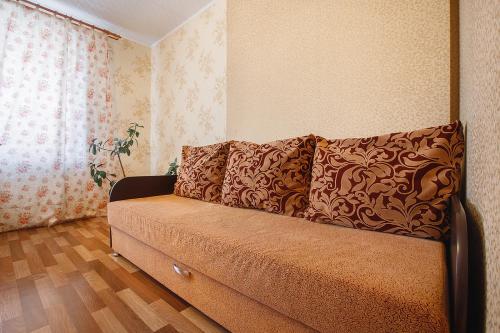 トムスクにあるАпартаменты на Савиныхの窓付きの客室で、茶色のソファが備わります。