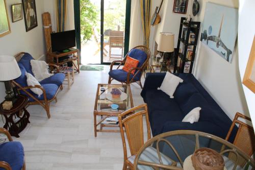 a living room with blue couches and chairs at Pasha Bay Residence in Sounio