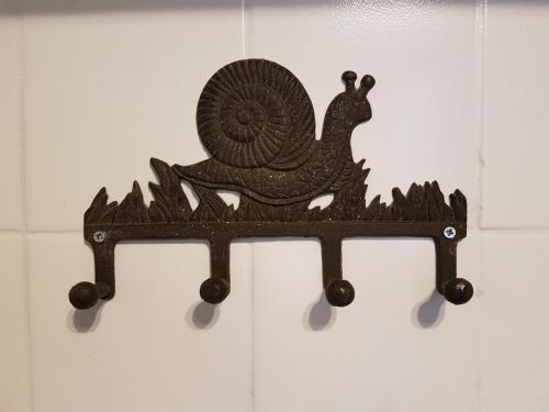 a wooden bird ornament hanging on a wall at Hôtel-Restaurant "Chez Carrière" in Aigues-Mortes