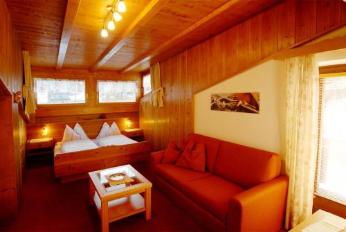 um quarto com um sofá e uma cama numa cabina em Garni Waldfrieden em Castelrotto