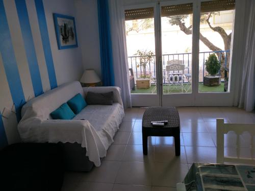 una sala de estar con un sofá y una mesa en Apartamento primera línea de mar, en Hospitalet de l'Infant