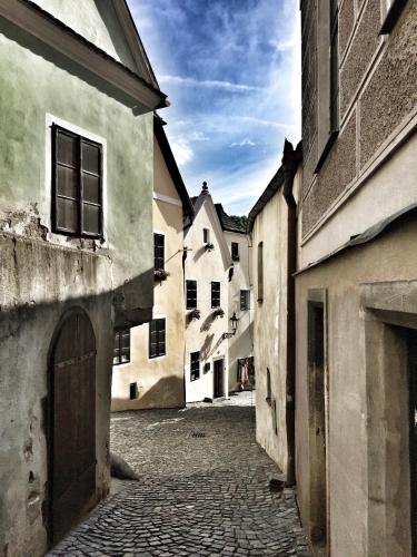 an empty street in an old town with buildings at Penzion U náměstí - At the Town Square in Český Krumlov