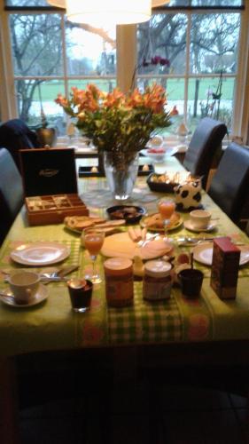 een tafel met eten en een laptop erop bij B&B Marialin in Wijdewormer