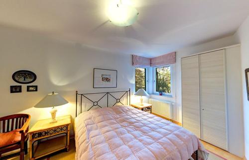 a bedroom with a bed and two lamps and a window at Villa Seepark - Ferienwohnung 5 in Heringsdorf