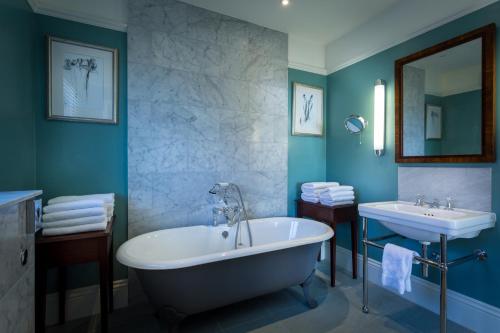 a bathroom with a tub and a sink at Roslin Beach Hotel in Southend-on-Sea