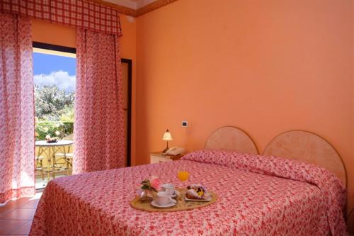 - une chambre avec un lit doté d'un couvre-lit rose dans l'établissement Fattoria Belvedere, à Bellaria-Igea Marina