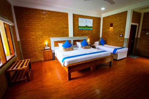 a bedroom with two beds with blue pillows at Elephas Resort & Spa in Sigiriya