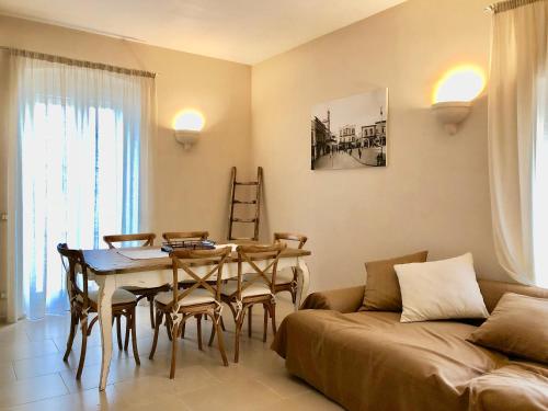 - un salon avec une table, des chaises et un canapé dans l'établissement Palazzotto "Fasano Antica", à Fasano