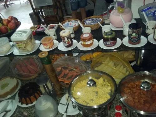 a table topped with lots of different types of food at Pousada Irashai in Juquei
