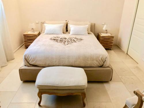 - une chambre avec un grand lit et un tabouret dans l'établissement Palazzotto "Fasano Antica", à Fasano