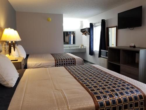 a hotel room with two beds and a flat screen tv at Old Bardstown Inn in Bardstown