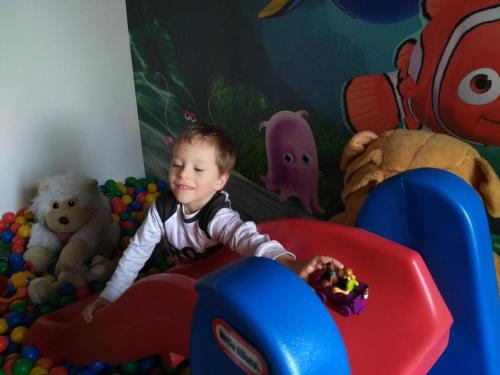 a young boy playing in a play room with toys at Hotel Kreta in Kutná Hora