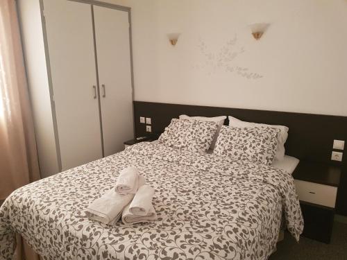 een slaapkamer met een bed met twee handdoeken erop bij Galanopoulos Hotel in Loutraki