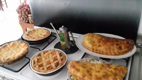 a stove top with four pies in pans on it at L'Oasi in Auletta