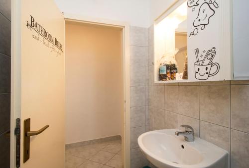 a bathroom with a sink and a mirror at Apartment & Rooms Marigold in Baška Voda