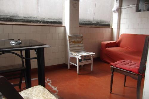 a room with a table and a chair and a couch at Tião Botelho Guest House in Rio de Janeiro