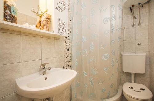 a bathroom with a sink and a toilet at Apartment & Rooms Marigold in Baška Voda