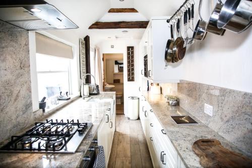 a kitchen with white counters and a stove top oven at Stoney Lane in Thaxted