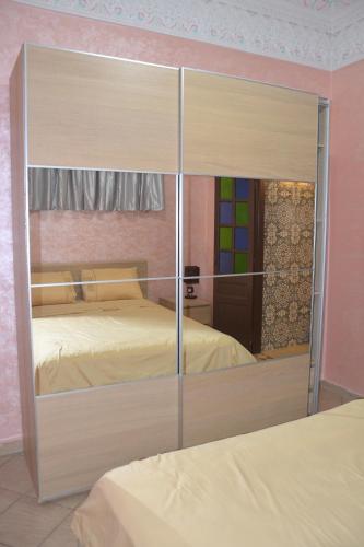 a large mirror in a bedroom with two beds at Médina Flat in Rabat