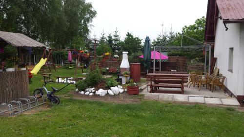 a backyard with a park with a playground and a bench at POKOJE GOŚCINNE RENATA KNITTER in Komnino