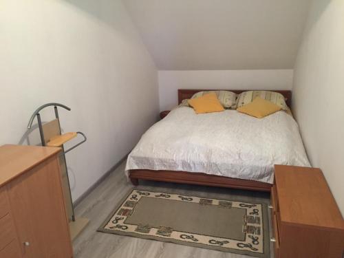 a small bedroom with a bed and a rug at POKOJE GOŚCINNE RENATA KNITTER in Komnino