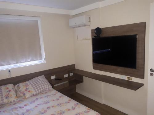 a bedroom with a bed and a flat screen tv at Maceió Pajuçara Ed. Neo 1 in Maceió