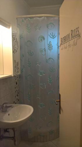 a bathroom with a shower curtain with a sink at Apartment & Rooms Marigold in Baška Voda