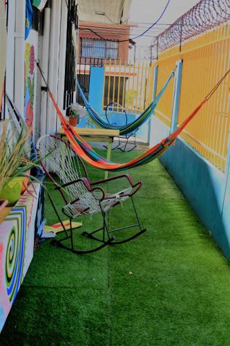 a patio with a hammock and a table and chairs at In the Wind Hostel and Guesthouse in San José