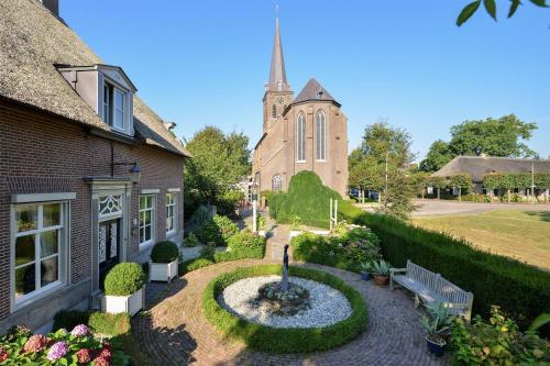 a church with a fountain in front of a building at De Oude Pastorie Macharen in Macharen