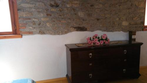 Un dormitorio con un tocador con flores. en Il Borgo dei Laghi en Revine Lago