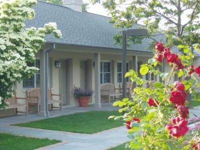 a house with a porch with benches and flowers at Southampton Long Island Hotel in Southampton