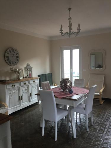 a dining room with a table and chairs and a clock at Sweet Caselle in Testico