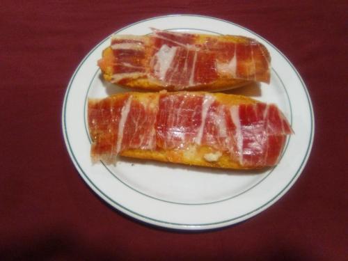 dos trozos de tocino en un plato en una mesa en Hotel Romero Merida, en Mérida