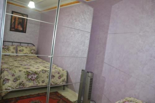 1 dormitorio con 1 cama y pared de cristal en Stay Studio Apartment, en Rabat