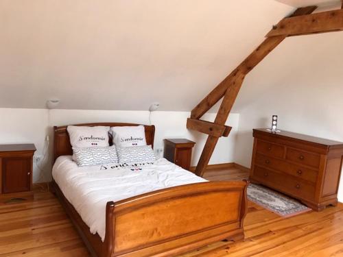 - une chambre avec un lit en bois et une commode en bois dans l'établissement le clos du caribou, à Beaumont-Hamel