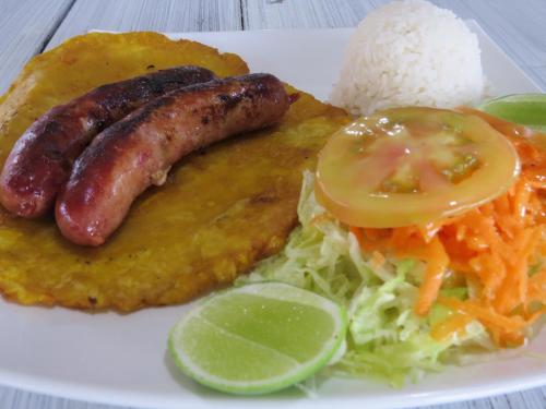 a plate of food with sausage and rice and lettuce at Hotel Recreacional Marcelandia Santa Rosa de Cabal in Santa Rosa de Cabal