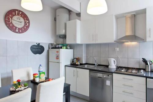 a kitchen with white appliances and a table and chairs at Casa da Foz in Porto