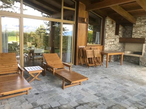 a patio with wooden benches and a table and chairs at Pirin Golf Villa Emila in Bansko