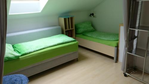 Habitación con 2 literas y sábanas verdes. en Ferienwohnung Stricker, en Obertraun