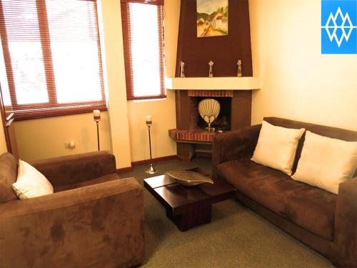 a living room with two couches and a fireplace at Altura Rooms & Suites in Quito
