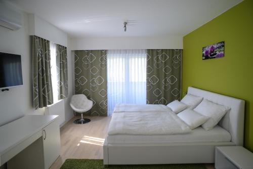 a bedroom with a white bed and green walls at Villa Lika in Plitvička Jezera