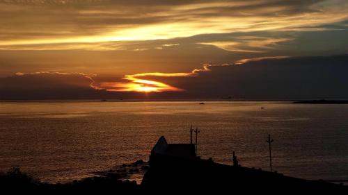 a sunset over a large body of water at Jama Bay in Xiyu