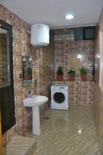 a bathroom with a washing machine and a sink at House City Center in Rabat