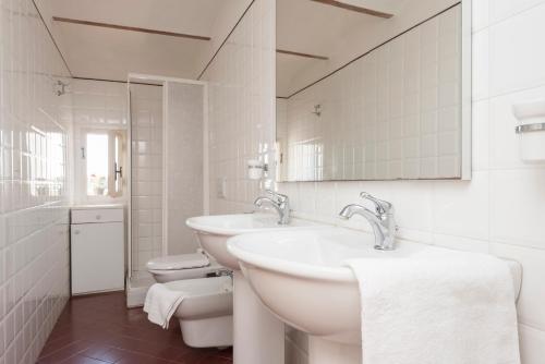 bagno bianco con lavandino e servizi igienici di Borgo e Castello a Suvereto
