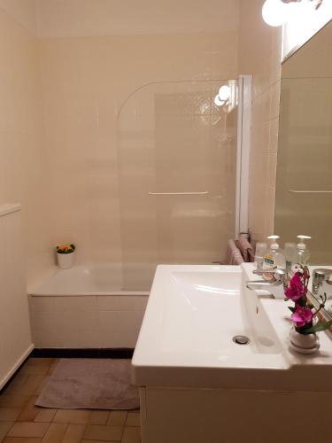 a white bathroom with a sink and a bath tub at Mei Hôtel-Restaurant in Sarrebourg