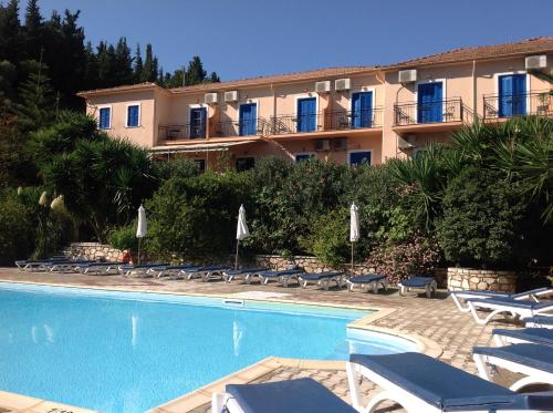 a resort with a swimming pool and chairs and a building at Hotel Nostos in Frikes